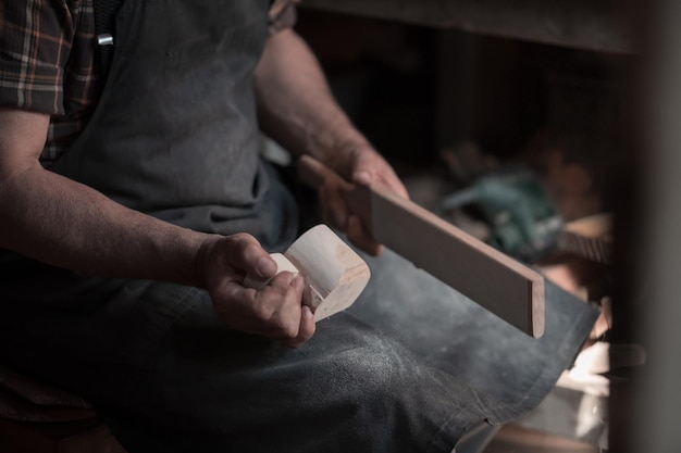 Hands carving cup from wood, working with chisel close up. Wooden workshop. Process of making wooden kitchenware High quality photo