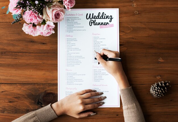 Photo hands checking on wedding planner checklist