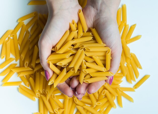 Photo the hands of the chef holding in his hands italian pasta