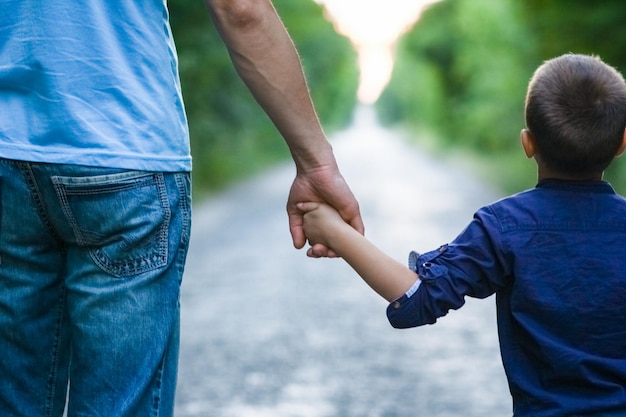 A Hands of a child and a parent in nature on the road journey background