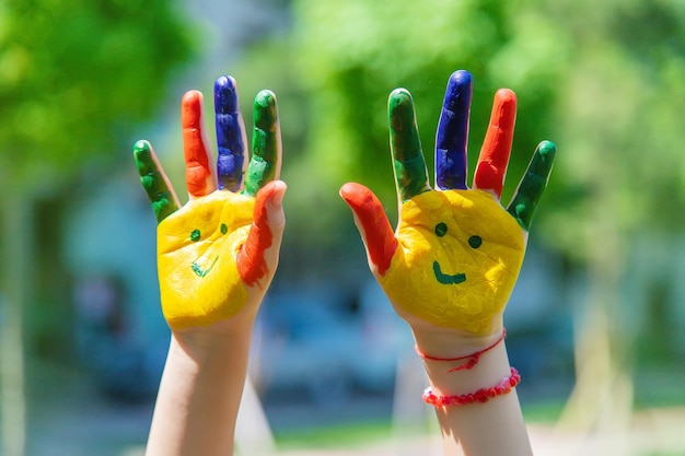 Mani di un bambino con un sorriso dipinto messa a fuoco selettiva