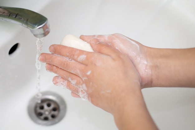 Hands of child with soap. Washing, sanitizing hands with antibacterial soap