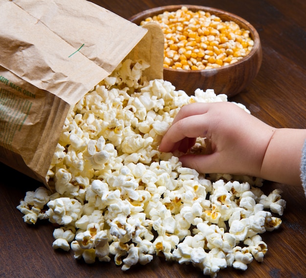 Mani dei bambini che mangiano popcorn