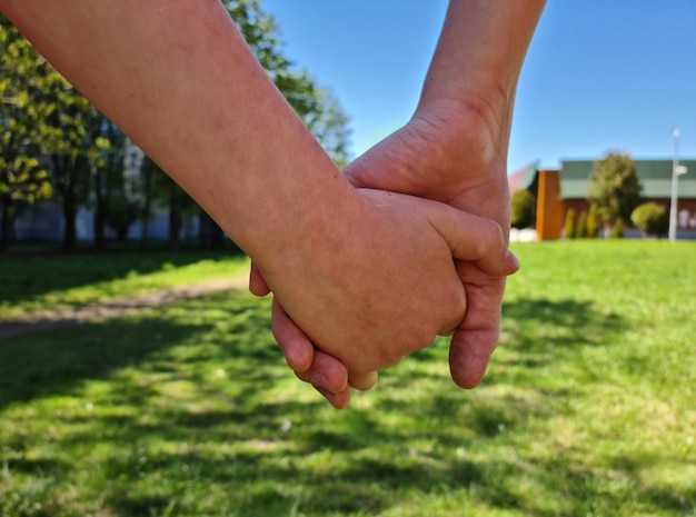 Hands of children friends and summer nature outdoors