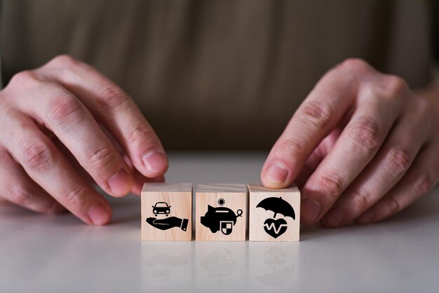 Hands choose a cube of wooden toy blocks with a badge of insurance family safety and health insuran