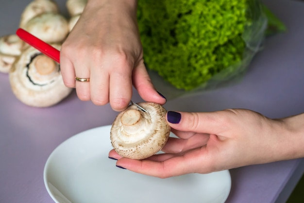 Photo hands clean mushrooms with knife