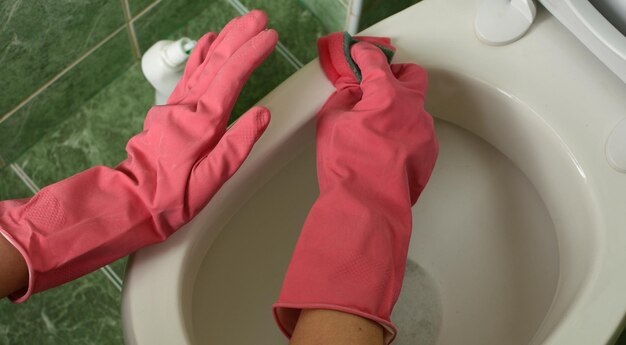 Hands cleaning the toilet