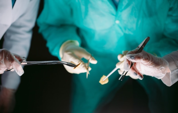 Hands close-up of surgeons holding medical instruments. The surgeon makes an operation.