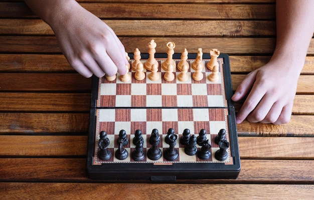 Hands of a concentrated child playing chess