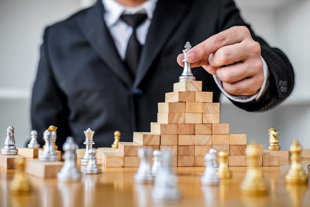 Hands of confident businessman playing chess game to development analysis new strategy plan