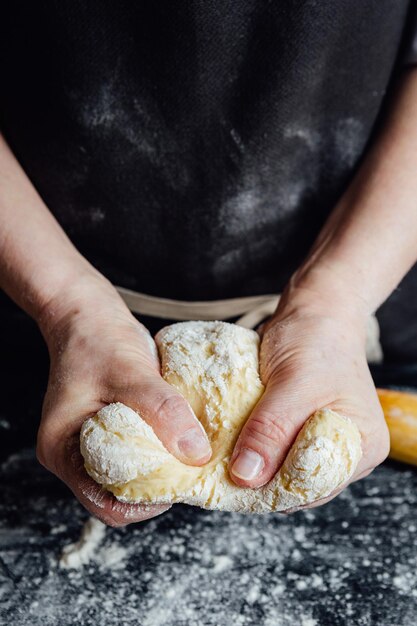 Hands of cook beating up pastry for cookies Vertical studio shot