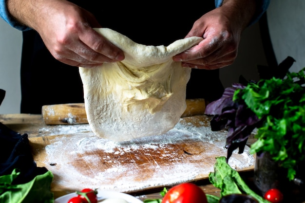 Hands of cook italian chef cooking pizza man hands cooking pizza dough for pizza chefs hands