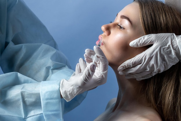 Руки косметолога делают инъекции в губы молодой женщине делают инъекции красоты в лицо в са