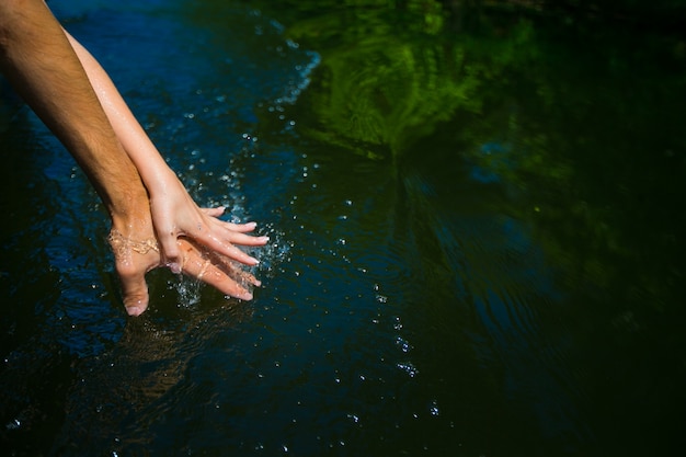 Photo hands of a couple stuck in the water