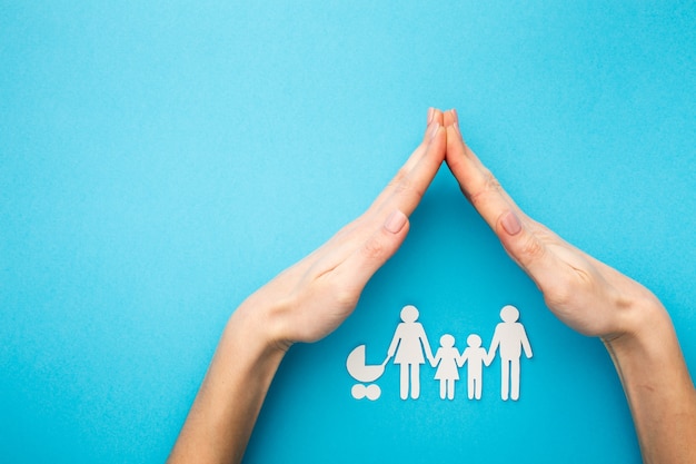 Hands covering family figure with copy space