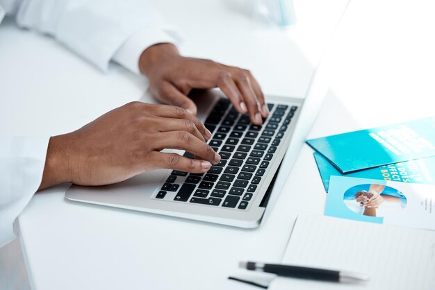 Hands covid and laptop with a doctor typing a report or diagnosis for treatment in a hospital office Computer documents and medicine with a health professional working in a healthcare clinic