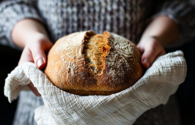 Foto mani che abbracciano un pane appena cotto in una cucina accogliente