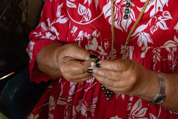 Hands crafting Polynesia shell necklage