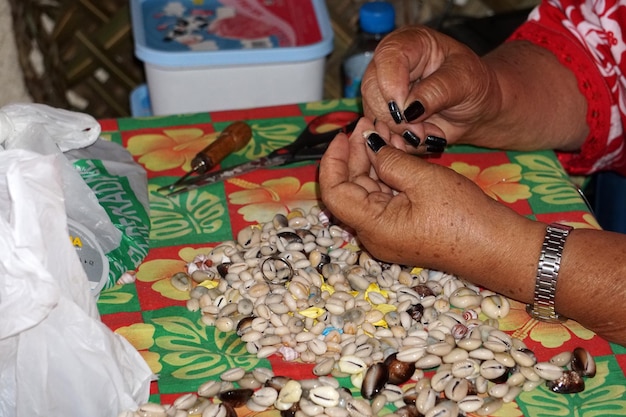 Hands crafting Polynesia shell necklage