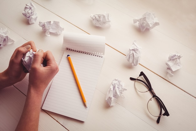 Photo hands crumpling paper on wooden desk