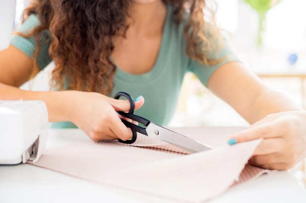 Hands cutting cloth with scissors