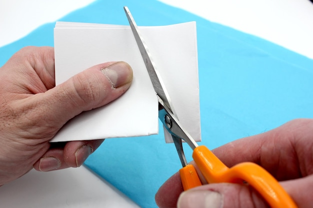 Hands cutting paper with scissors