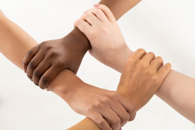 Photo hands of different races ethnically hold their wrists together