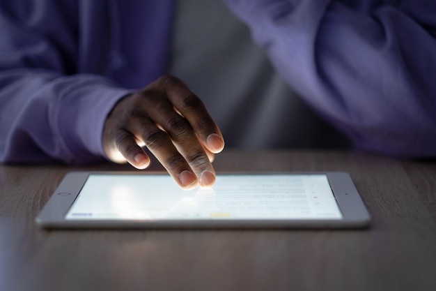 デジタルタブレットキーボードのハンズアップは、アフリカ系アメリカ人の男性のオフィスワークをリモートで入力しますメモ帳コンピューターを使用して黒人のフリーランサー遠隔学習オンライン教育と仕事