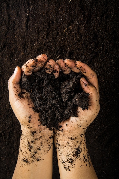 Hands dirty with clay soil background