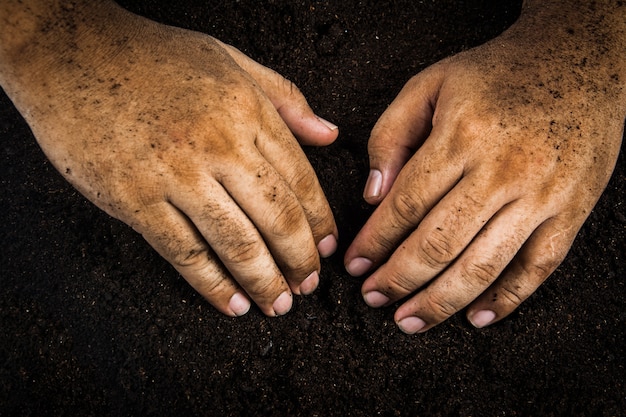 Hands dirty with clay , soil background 