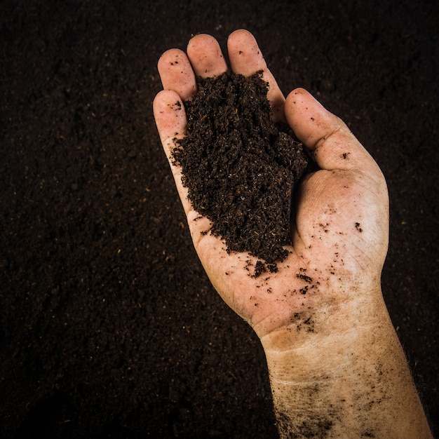 Hands dirty with clay , soil background 