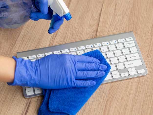 Foto mani che disinfettano la superficie della tastiera con un panno e un'abluzione