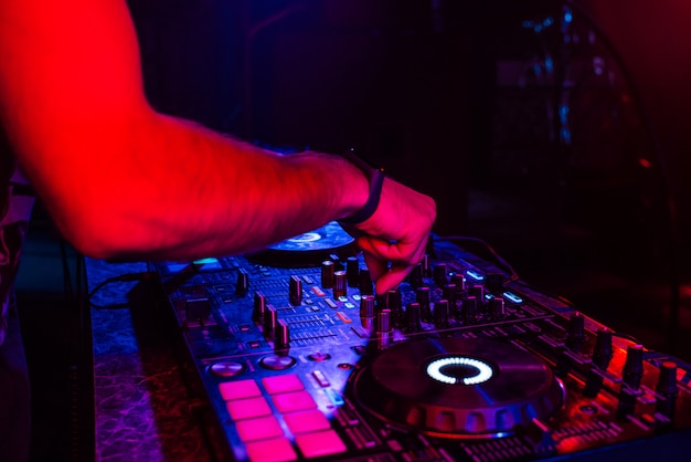 Hands of a DJ mixing music on a professional controller in a booth