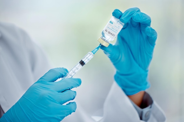 hands of doctor with covid vaccine and needle for help support and safety protection from covid 19 pandemic medical healthcare worker hospital nurse or corona virus expert with medicine innovation