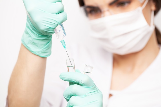 Hands of the doctors filling a syringe