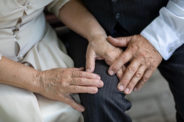 Hands of elderly people holding hands close up