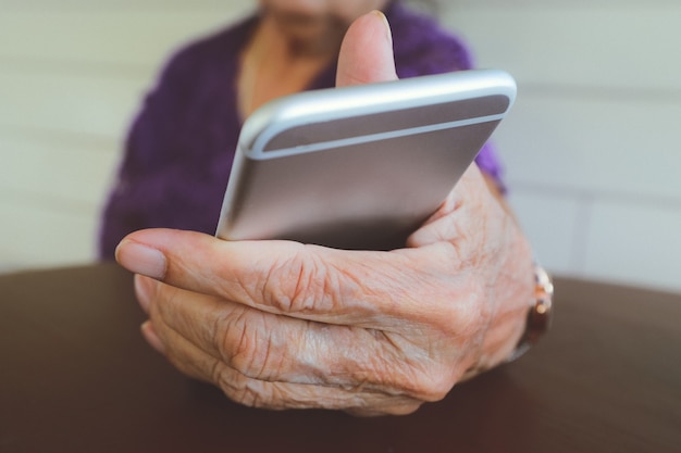 Hands of an elderly woman holding a mobile phone