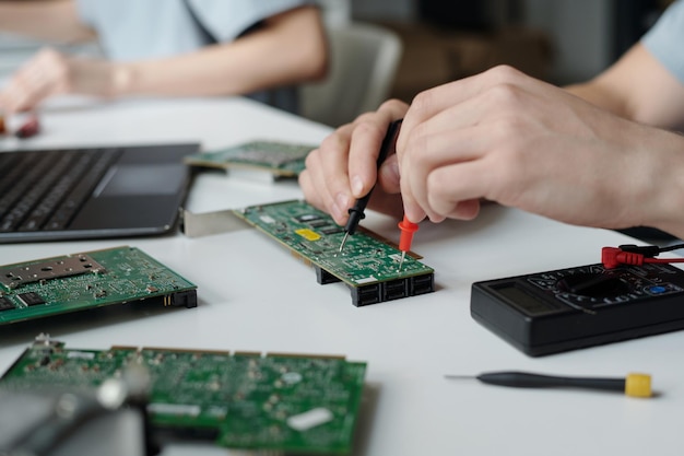 Hands of engineer checking motherboard