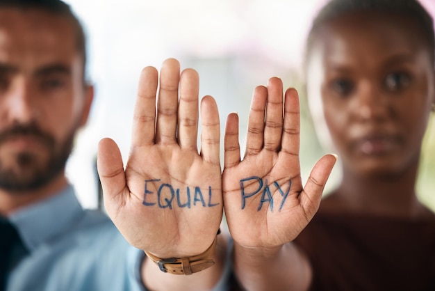 Foto uguaglianza ed emancipazione delle mani con un uomo e una donna d'affari che mostrano un avviso di parità salariale nei loro palmi comunità di squadra e collaborazione con colleghi maschi e femmine che stanno insieme in unità