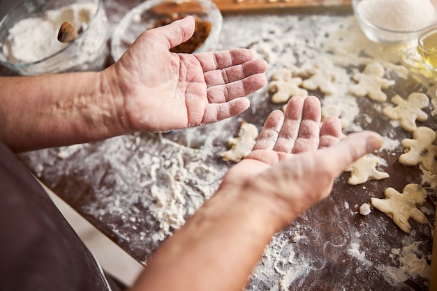 Hands of experienced baker being covered in flour