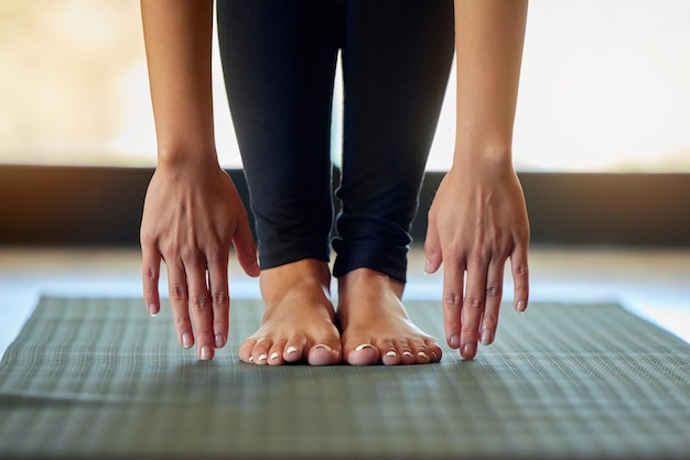 Photo hands feet and woman stretching on yoga mat for exercise cardio and flexibility warm up in her home barefoot hand and girl stretch for meditation training for pilates workout in a living room