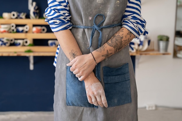 Hands of female artisan after working with raw clay in pottery studio Pottery business and workshop