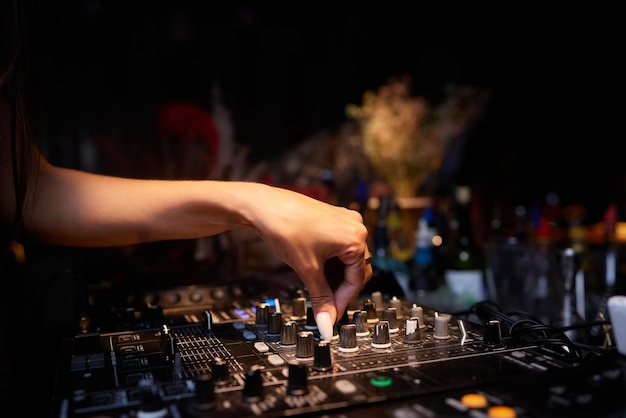 Hands of female dj playing music on modern midi controller turntable digital device for mixing music