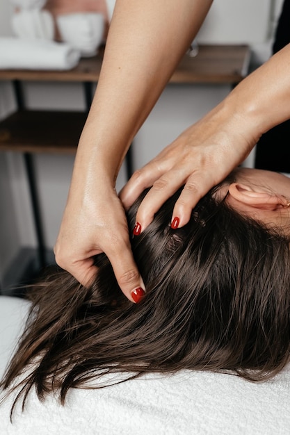 Photo hands of a female professional facial masseur at work in a beauty salon