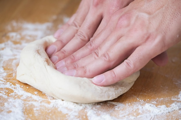 Hands and fingers of a person making pizza