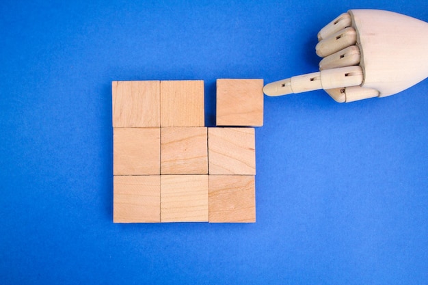 手は木製の立方体を四角に積み上げます。ソリューションのコンセプト。問題解決のコンセプト