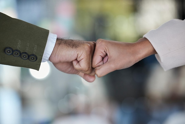 Hands fist bump and trust in corporate partnership for unity agreement or deal against blurred background Hand of people bumping fists in collaboration for teamwork goals or support for winning