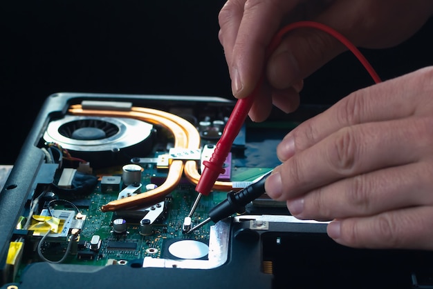 Hands fixing motherboard of pc or laptop notebook close up in service