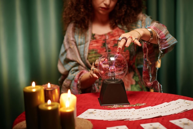 Hands of fortune teller gazing into crystal ball to see fortune