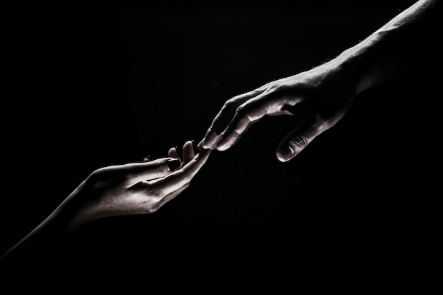 Premium Photo  Hands gesturing on black background giving a helping hand  support and help salvation hands of two people at the time of rescue  romantic touch with fingers love hand creation